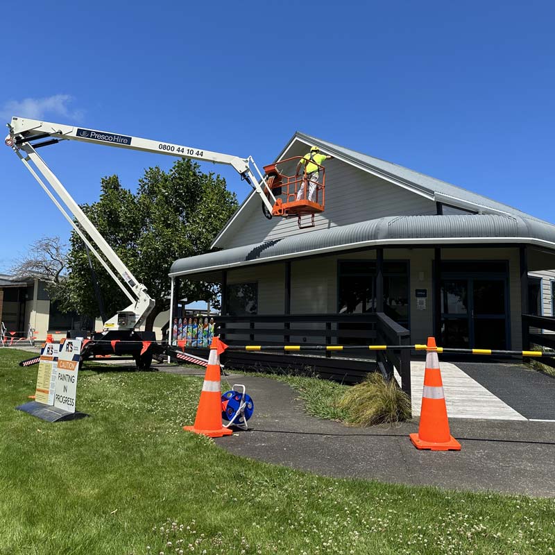 painting a school roof with a boon